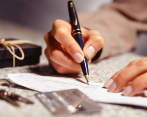 Woman signing receipt in office, (Close-up)